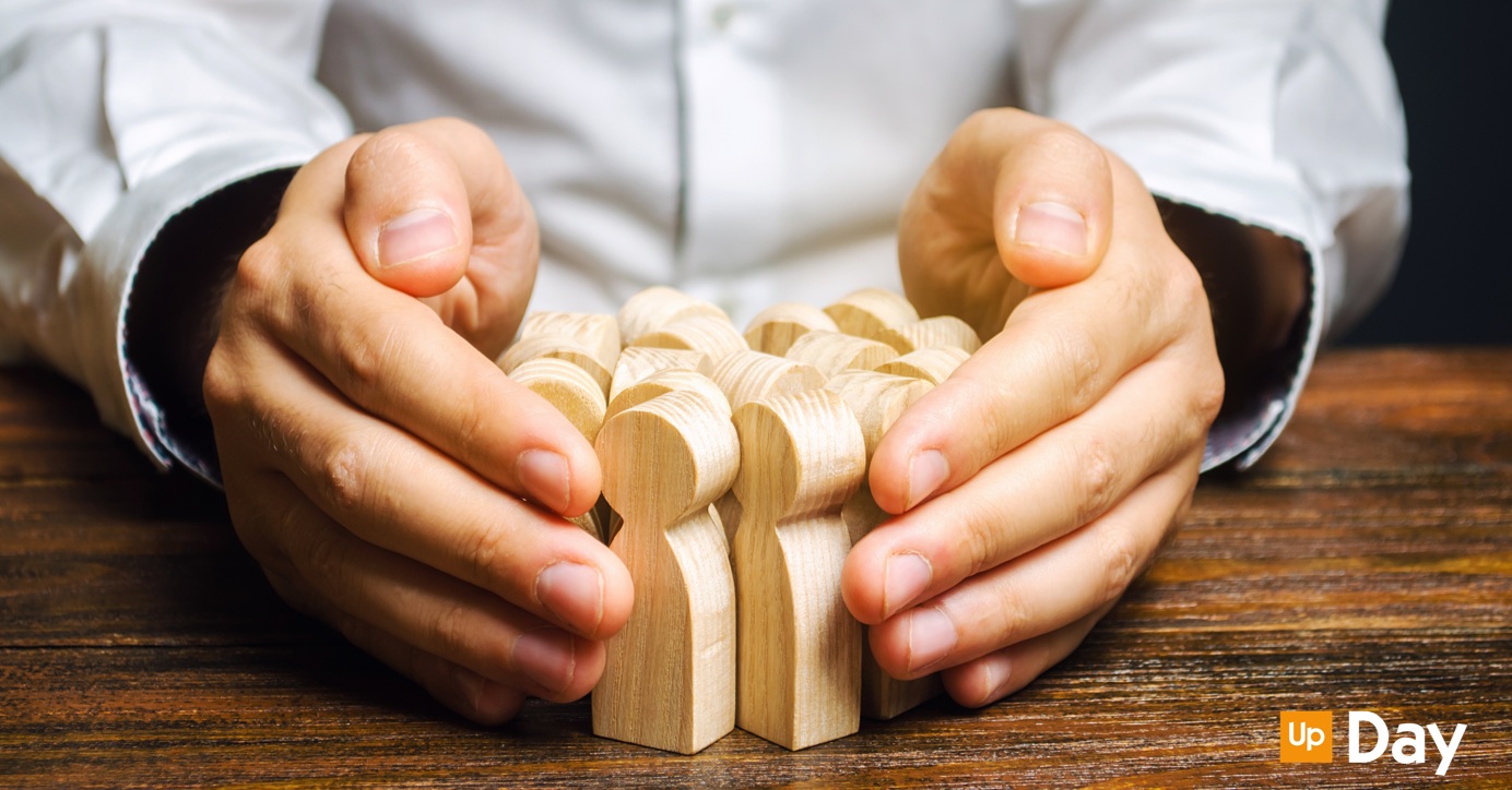 Trattenere i talenti in azienda, un hr che tiene fra le mani delle pedine che rappresentano i dipendenti