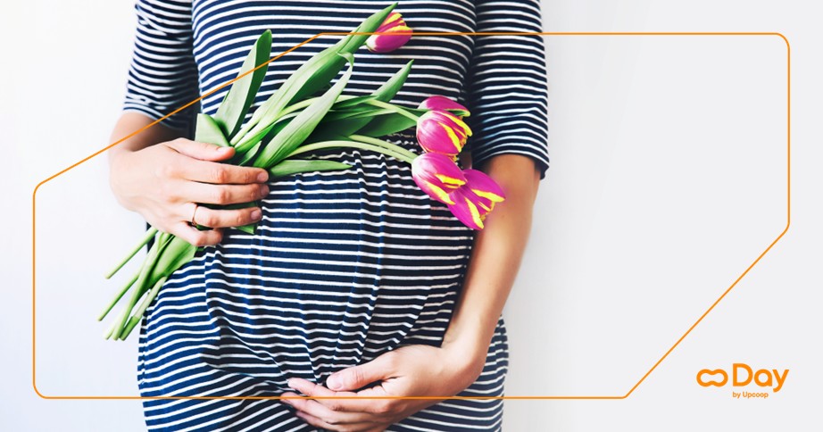 Una donna incinta tiene in mano un mazzo di fiori